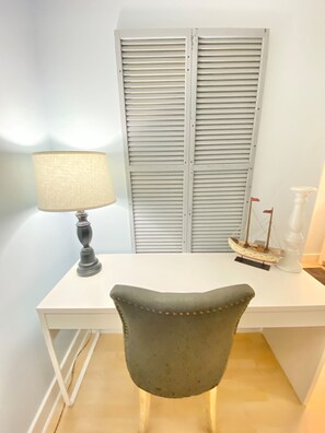 Work in comfort with a desk and chair, plus a soft light source and shutters.