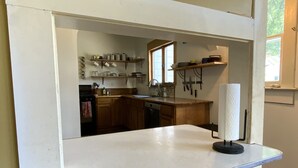 A kitchen with wooden cabinets, a countertop, and a window.