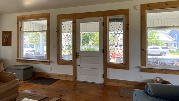 A spacious living area with a large window, a door, and a seating area with a sofa and a coffee table.