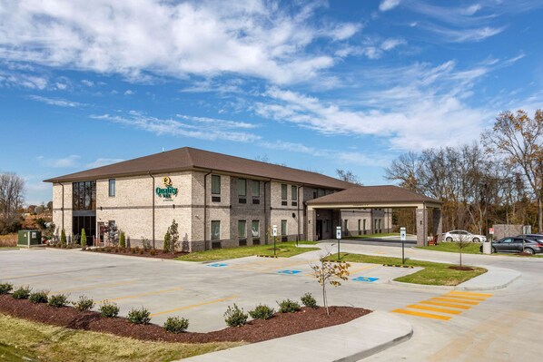 A building with a brick facade, a parking lot with marked handicapped spaces, and a clear sky. - Quality Inn Lebanon - Nashville Area (Lebanon)