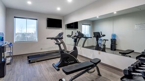 A gym with exercise equipment, a treadmill, a stationary bike, and a bench. - Quality Inn Lebanon - Nashville Area (Lebanon)