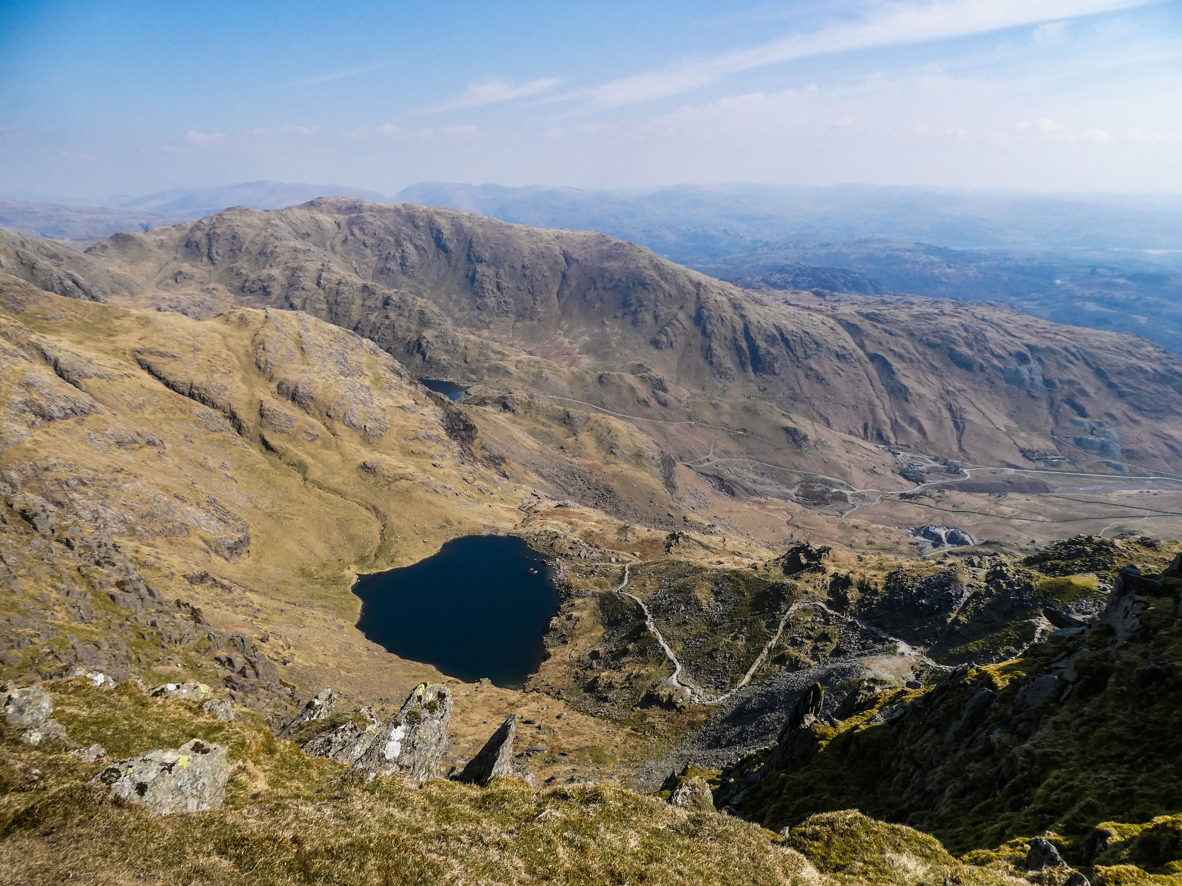A mountainous landscape with a lake and distant hills.