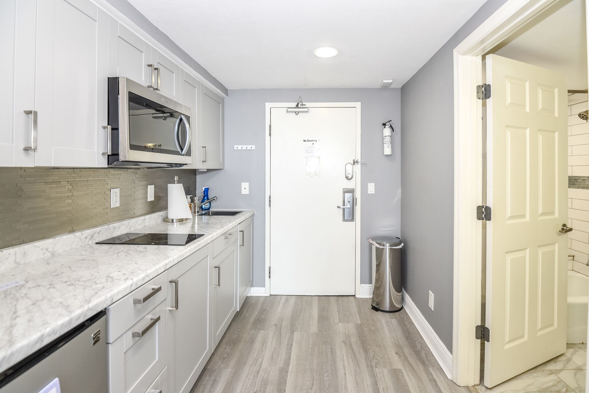 A modern kitchen with a microwave, sink, and cabinets.