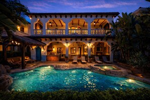 A large house with a swimming pool, outdoor seating, and a covered patio area. - The Spanish Castle | West facing pool, SPA and views of Jack Nicklaus Golf Course (Kissimmee)