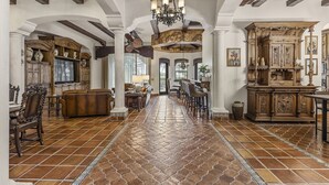 A spacious living area with a high ceiling, ornate wooden furniture, and a tiled floor. - The Spanish Castle | West facing pool, SPA and views of Jack Nicklaus Golf Course (Kissimmee)