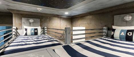 A room with bunk beds, a starry ceiling, and a window with a view of the sky.