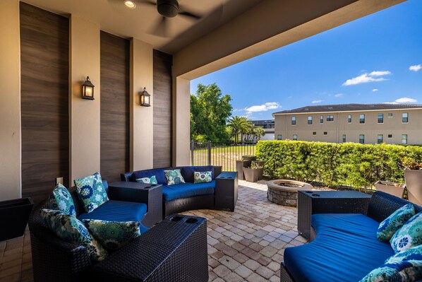 Relax on the patio surrounded by a beautifully landscaped garden and a cozy fire pit.