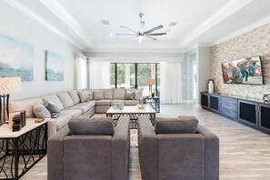Relax in this stylish living area with a large L-shaped sofa, armchair, and flat-screen TV.