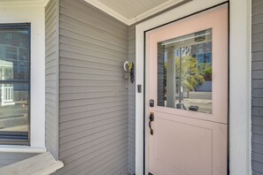 A house with a pink front door, a mailbox, and a small window.