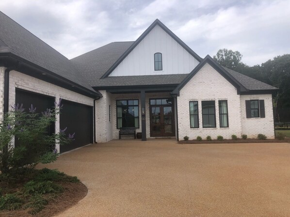 A two-story house with a garage, a front porch, and a driveway.