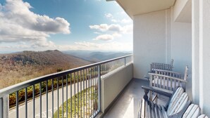 Un balcón con vistas a montañas y una carretera.