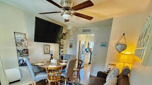 A modern living room with a dark gray sofa, a wooden coffee table, and a ceiling fan. -  Cozy Historic Farmhouse-2 Bedroom Downstairs Unit - Walk Downtown & Whiskey Row (Prescott)