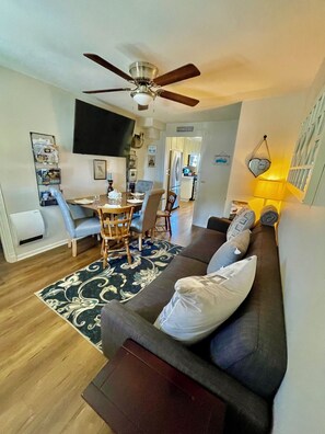 A modern living room with a dark gray sofa, a wooden coffee table, and a ceiling fan.