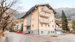 Un hotel a più piani con balconi, situato in una zona montuosa sotto un cielo sereno.