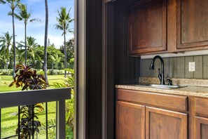 Enjoy a serene view of the lush garden from the kitchen, where you can prepare a meal while surrounded by tropical plants.