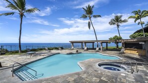 Ein Poolbereich mit Blick auf das Meer, Liegestühle und eine Pergola.