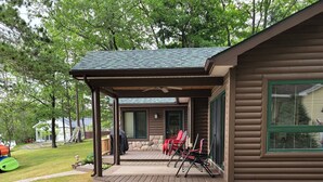 Une cabane dotée d’une terrasse couverte, d’un foyer extérieur et de sièges pour profiter de l’extérieur.