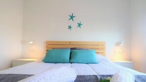 Un lit avec une tête de lit en bois, deux oreillers et une couverture.