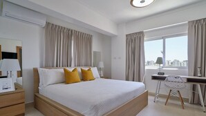 Una habitación de hotel moderna con una cama grande, un escritorio y una silla.