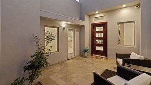 Un patio con una puerta, una mesa pequeña y una silla.