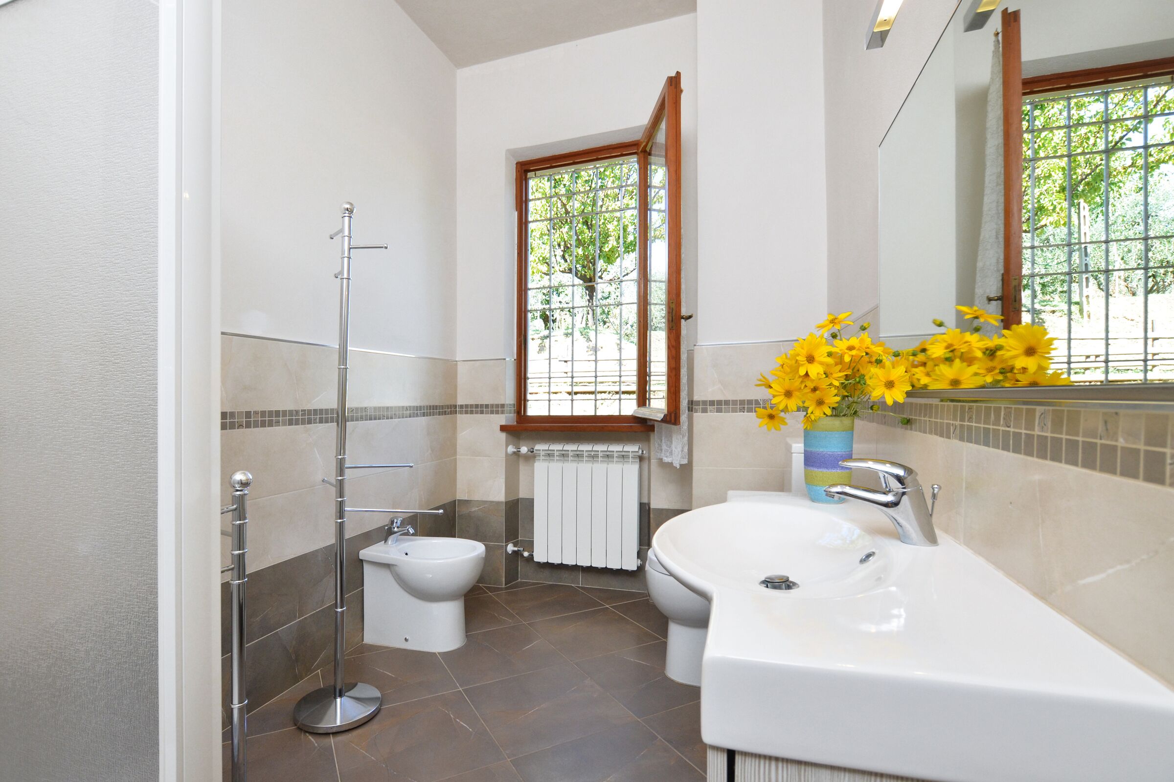 A bathroom with a bidet, toilet, and sink.