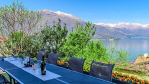 An outdoor dining area with a table set for two, overlooking a lake and mountains. - Villa Canonica by Interhome (Varenna)