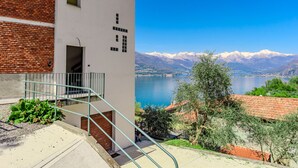 A building with a staircase leading to a balcony overlooking a lake and mountains. - Villa Canonica by Interhome (Varenna)