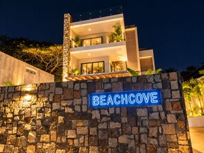 Ein modernes, zweistöckiges Gebäude mit einer steinernen Fassade und einem Schild mit der Aufschrift 'BEACHCOVE'.