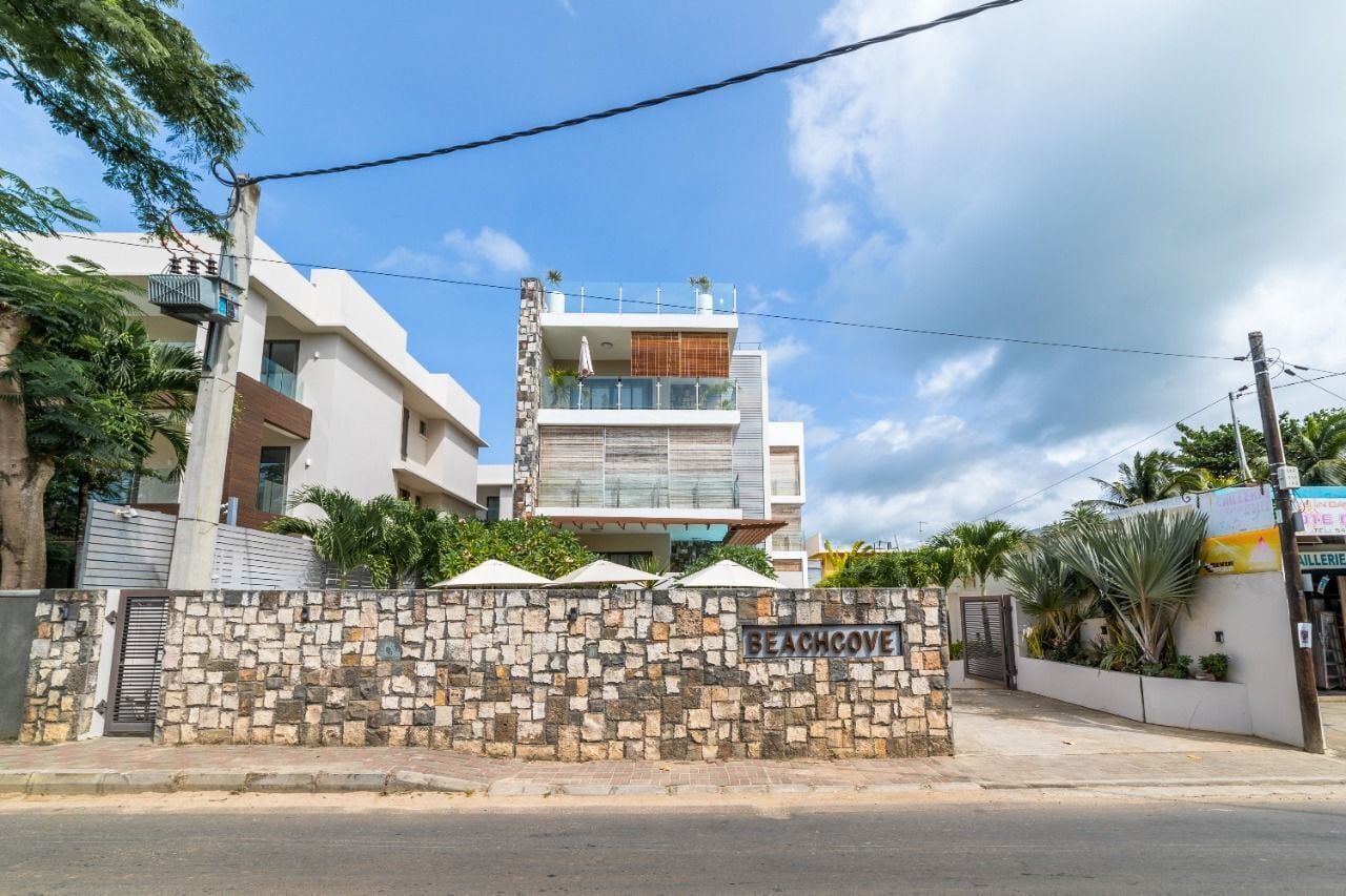 Un edificio moderno de varios pisos con un muro de piedra con la leyenda 