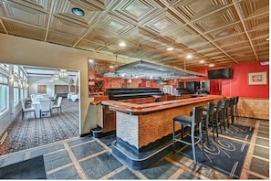 A bar area with a wooden ceiling, a counter, and bar stools. - Melour Resort (Tannersville)