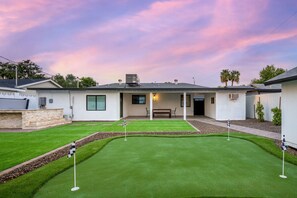 A residential property with a well-maintained lawn, a patio area, and a house with a flat roof. - Monterosa Green - BEST WALKABLE LOCATION in Charming Arcadia Lite w/ SPA! (Phoenix)