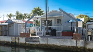 A house with a porch, a grill, and a small shed. - Anchor's Away: Discover Charm on the Canal, Swift Atlantic Access, Dockage & Above Ground Pool Await (Marathon)
