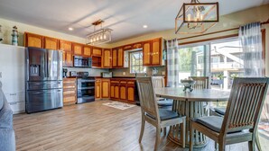 A spacious kitchen with wooden cabinets, stainless steel appliances, and a dining area with a table and chairs. - Anchor's Away: Discover Charm on the Canal, Swift Atlantic Access, Dockage & Above Ground Pool Await (Marathon)