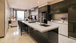 Cocina moderna con una isla central, muebles oscuros y un amplio ventanal con vistas a la ciudad.