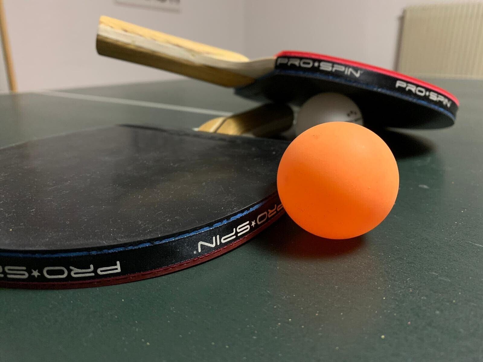 A table tennis table with a paddle and a ball.