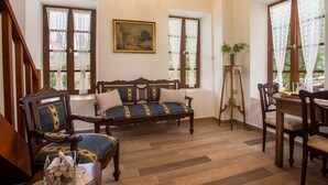 Une pièce comprenant un banc en bois, des chaises, une table à manger et un tableau accroché au mur.