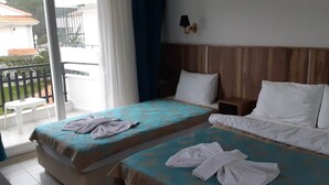 Una habitación de hotel con dos camas, un balcón y vistas al exterior.