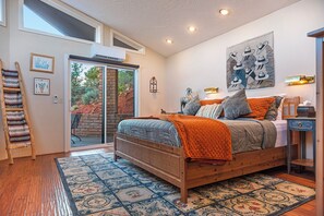 Une chambre à coucher avec un lit en bois, une grande fenêtre et une vue sur l’extérieur.