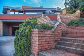 Un bâtiment moderne avec un mur en briques rouges, un escalier et un cactus.
