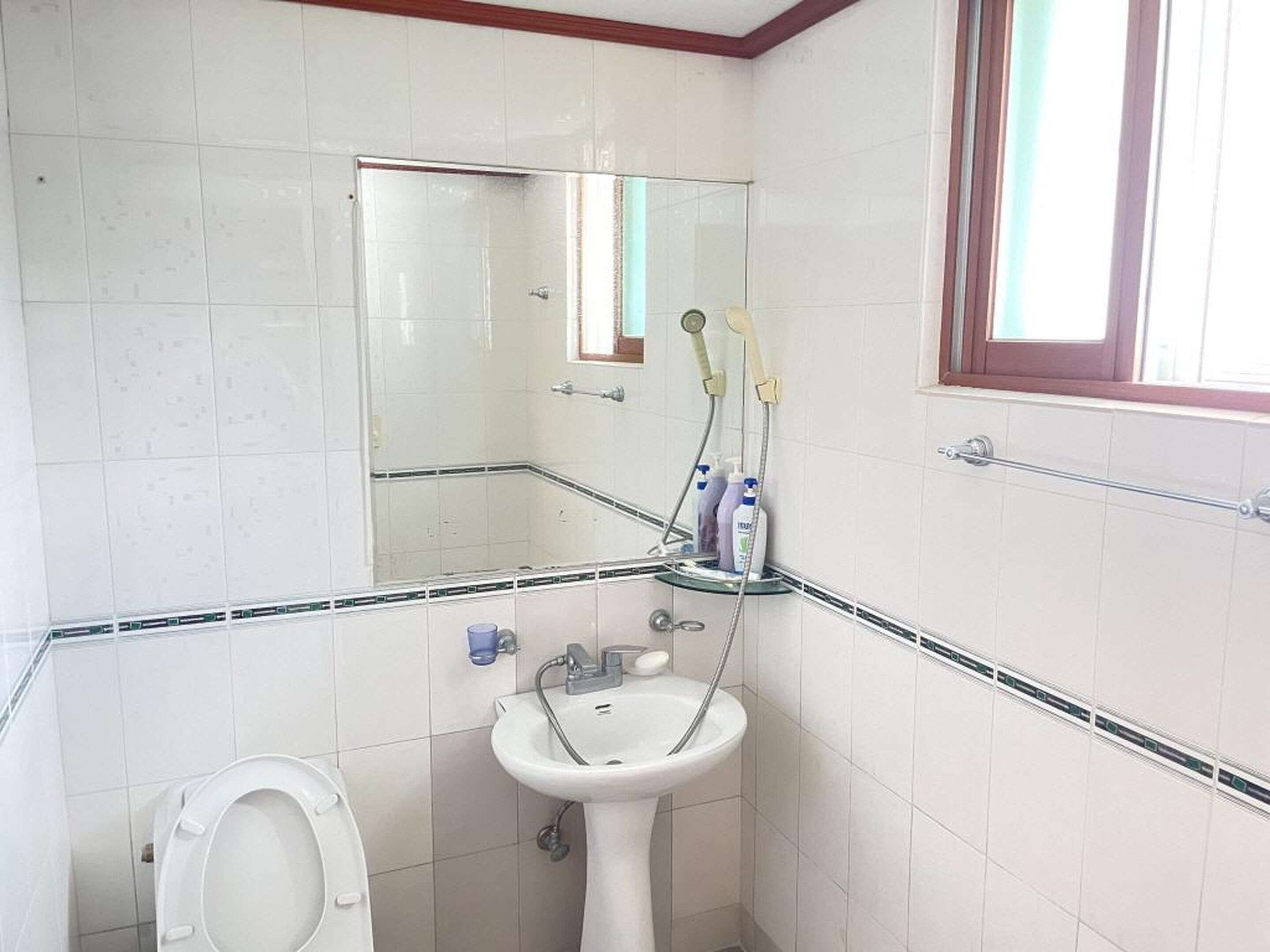 A bathroom with a toilet, sink, and shower.