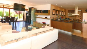 A modern living room with a sofa, a glass coffee table, and a dining area with chairs and a table. - Son Vigili 417 magnificent villa with private pool, jacuzzi, children's area and air-conditioning (Campos)