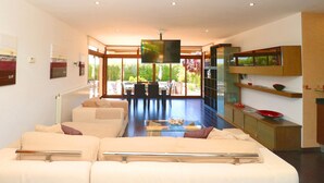 A modern living room with a sofa set, a glass coffee table, and a TV mounted on the wall. - Son Vigili 417 magnificent villa with private pool, jacuzzi, children's area and air-conditioning (Campos)