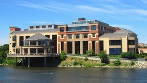 Un immeuble à plusieurs étages doté d’une architecture moderne, caractérisé par de grandes fenêtres et une galerie couverte.