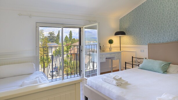 A bedroom with a balcony, a desk, and a bed with towels. - Pandora Stresa (Stresa)
