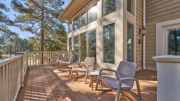 A wooden deck with outdoor furniture, large windows, and a view of trees. - Million Dollar View w/ 3 masters + Peloton on Pinehurst No. 9 (Pinehurst)