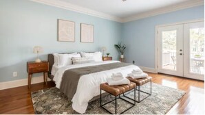 A bedroom with a bed, bedside tables, a ceiling fan, a window with a view, and a door leading outside. - Million Dollar View w/ 3 masters + Peloton on Pinehurst No. 9 (Pinehurst)