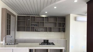 Una cocina moderna con una isla central, estanterías empotradas y un techo con focos.