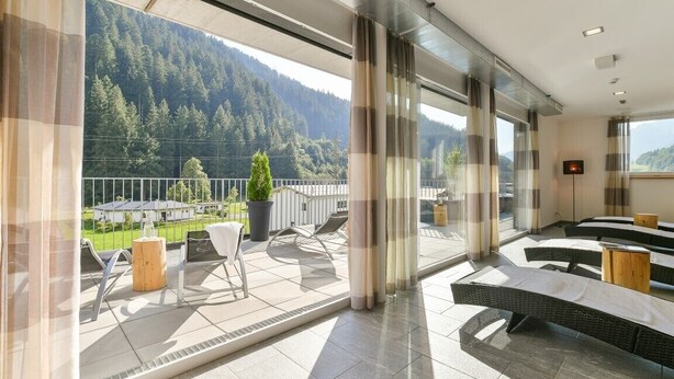 A modern hotel room with a balcony overlooking a mountainous landscape. - Chalet in the Alpine Lodge Klösterle (Klösterle am Arlberg)