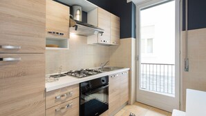 Una cocina moderna con armarios de madera, estufa a gas, horno empotrado y un amplio ventanal con vistas al exterior.