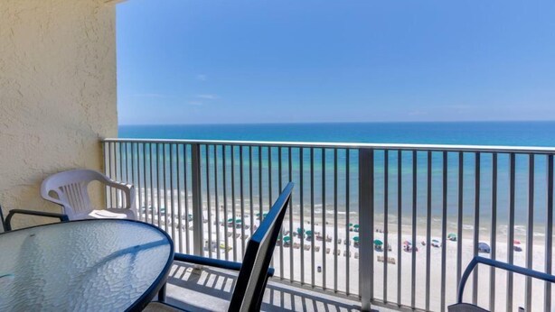 A balcony with a clear view of the beach and ocean.